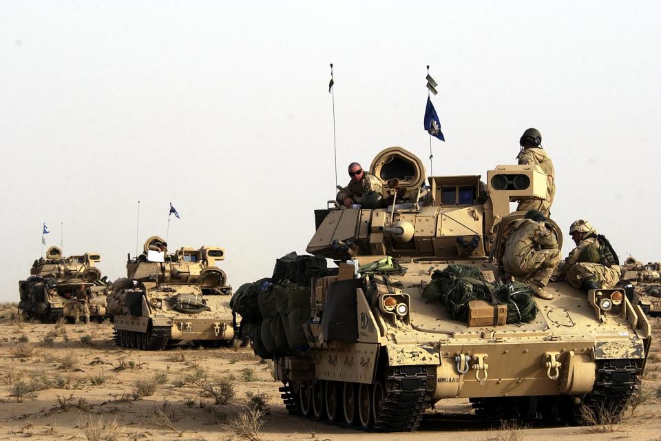 Troops of the U.S. Army 3rd Infantry Division 3-7 infantry gather on top of their vehicles during a pause.