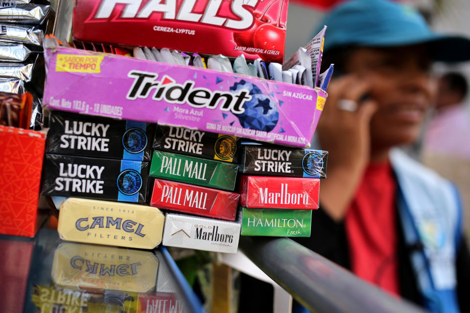 A woman sells cigarette packages of Lucky Strike, Marlboro, Pall Mall, Hamilton and Camel at a street in Lima, Peru. Photo: Mariana Bazo/Reuters