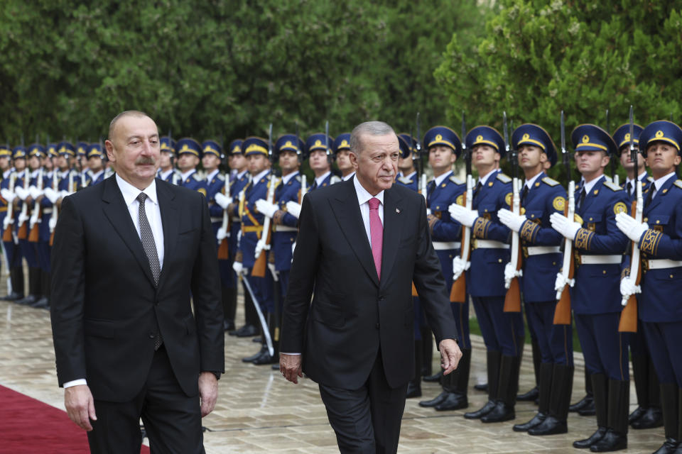 In this handout photo released by Turkish Presidency, Azerbaijan's President Ilham Aliyev, left, and Turkey's President Recep Tayyip Erdogan review an honor guard during a welcome ceremony in Nakhchivan, Azerbaijan, Monday, Sept. 25, 2023. Thousands of Armenians streamed out of Nagorno-Karabakh after the Azerbaijani military reclaimed full control of the breakaway region while Turkish President Recep Tayyip Erdogan visited Azerbaijan Monday in a show of support to its ally. (Turkish Presidency via AP)