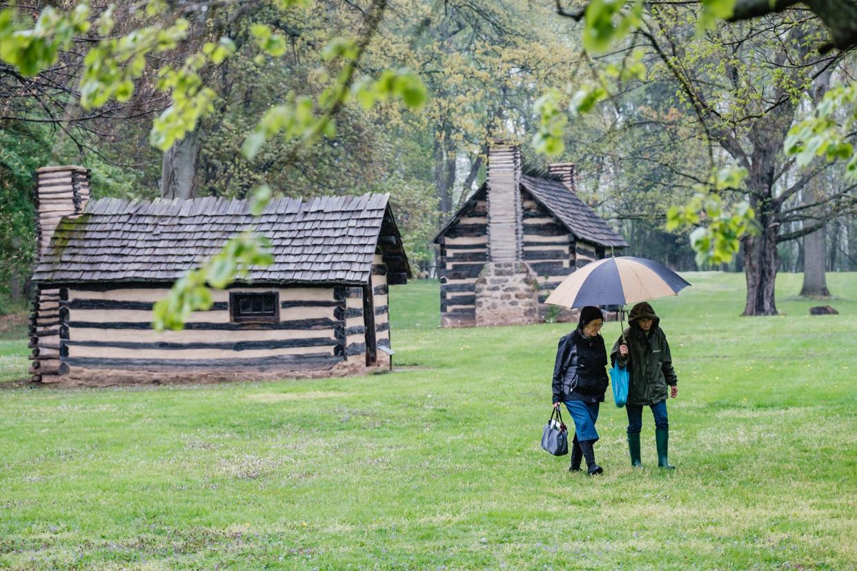 Women walk the grounds of the Historic Schoenbrunn Village during the 250th Anniversary Ceremony, in New Philadelphia.