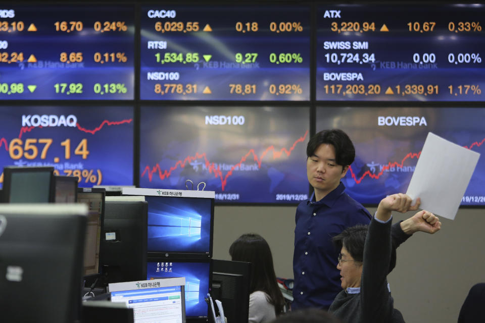 A currency trader stretches at the foreign exchange dealing room of the KEB Hana Bank headquarters in Seoul, South Korea, Friday, Dec. 27, 2019. Asian stocks followed Wall Street higher on Friday amid optimism U.S.-Chinese trade relations are improving. (AP Photo/Ahn Young-joon)