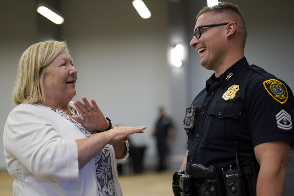 Houston Police Officer Matthew Simon, right, with the Special Operations Division, talks with Becky Edmondson about crime in her neighborhood during a National Crime Prevention Council workshop Thursday, Sept. 29, 2022, in Houston. (AP Photo/David J. Phillip)