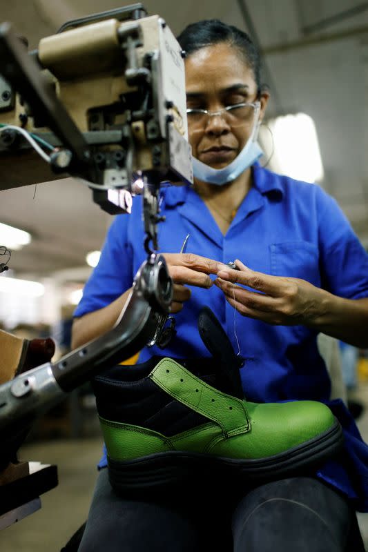 Un trabajador prepara un carrete de hilo en la fábrica de calzado Full Time, en Caracas