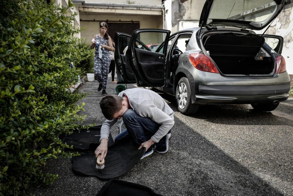 <span>Des jeunes des Coopératives jeunesses nettoient une voiture à Saint-Chamond, le 23 juillet 2018</span><div><span>JEAN-PHILIPPE KSIAZEK</span><span>AFP</span></div>