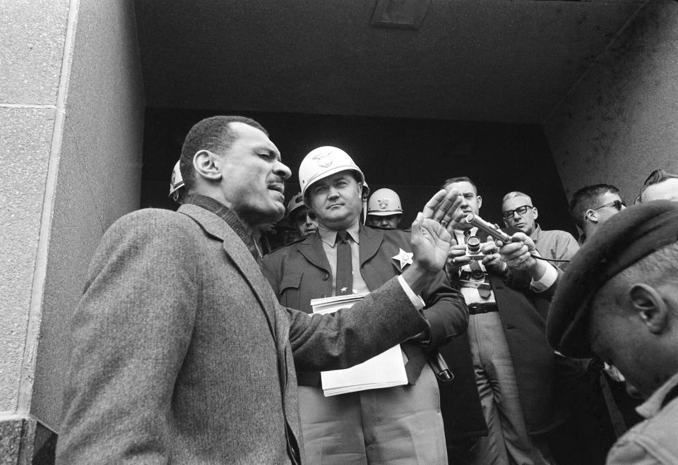 FILE - In this Feb. 5, 1965, file photo, C.T. Vivian, left, leads a prayer on the courthouse steps in Selma, Ala., after Sheriff James Clark, background with helmet, stopped him at the door with a court order. Vivian led hundreds of demonstrators carrying petitions asking for longer voter registration hours. A civil rights veteran, Vivian, who worked alongside the Rev. Martin Luther King Jr., and served as head of the organization co-founded by the civil rights icon, was awarded the Presidential Medal of Freedom and died in July 2020 in Atlanta. Jackson, Mississippi's current mayor declared Wednesday, May 26, 2021, as C.T. Vivian Day in the state's capital city. (AP Photo/Horace Cort, File)