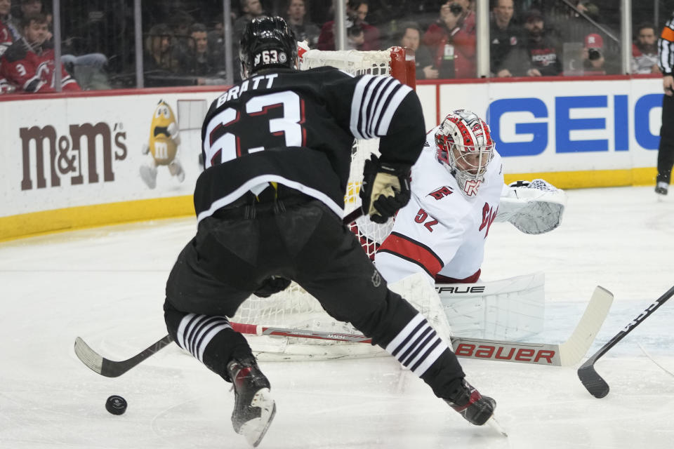 Carolina Hurricanes goaltender Pyotr Kochetkov (52) tends net as New Jersey Devils left wing Jesper Bratt (63) skates in during the second period of an NHL hockey game, Saturday, March 9, 2024, in Newark, N.J. (AP Photo/Mary Altaffer)