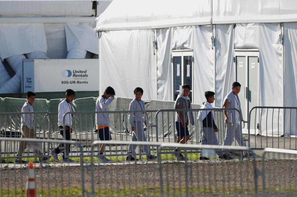 FILE - In this Feb. 19, 2019 file photo, children line up to enter a tent at the Homestead Temporary Shelter for Unaccompanied Children in Homestead, Fla. Immigrant advocates say the U.S. government is allowing migrant children at a Florida facility to languish in “prison-like conditions” after crossing the U.S.-Mexico border instead of releasing them promptly to family as required by federal rules. A court filing Friday, May 31, 2019 revealed conditions inside the Homestead, Florida, facility that has become the nation’s biggest location for detaining immigrant children. (AP Photo/Wilfredo Lee, File)