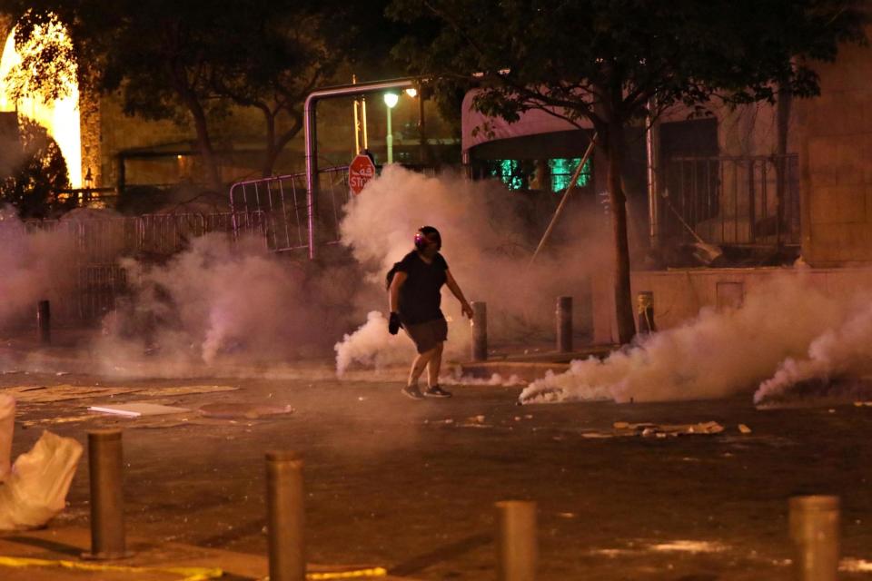 A demonstrator is pictured amid smoke rising from tear gas during a protest near parliament in Beirut (REUTERS)