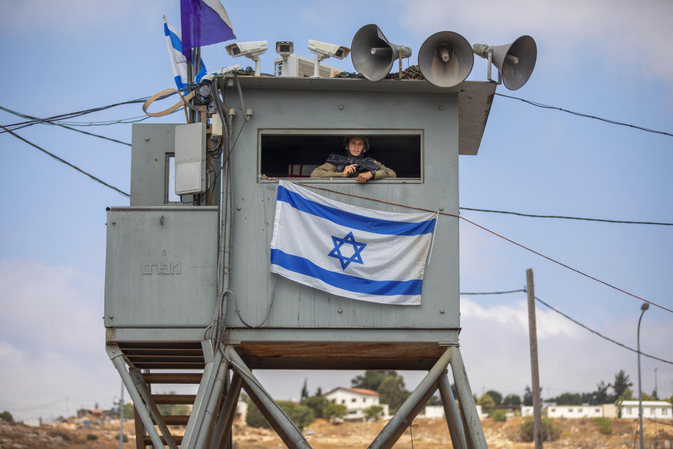 An Israeli soldier stands guard at the Tapuach junction next to the West Bank city of Nablus, Tuesday, June 30, 2020. Israeli Prime Minister Benjamin Netanyahu appears determined to carry out his pledge to begin annexing parts of the occupied West Bank, possibly as soon as Wednesday. (AP Photo/Oded Balilty)