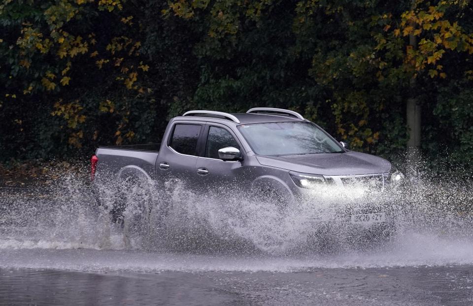 Cars pass through a flooded road in Ashford, Kent on Tuesday (Gareth Fuller/PA Wire)