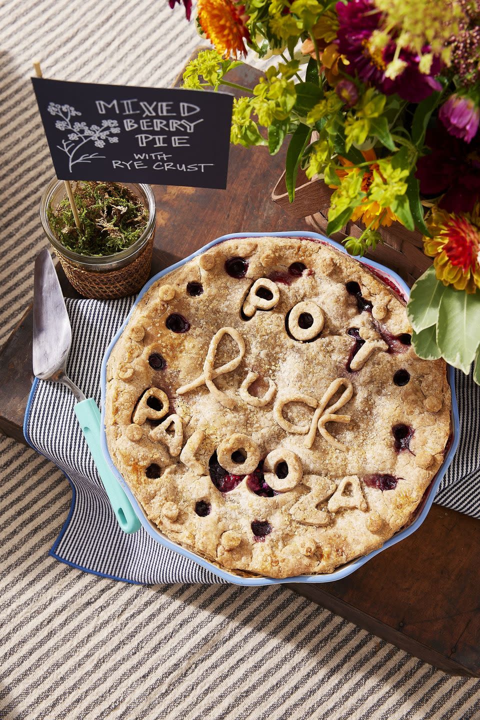 mixed berry pie with rye crust in a colorful patterned pie plate with light blue trim