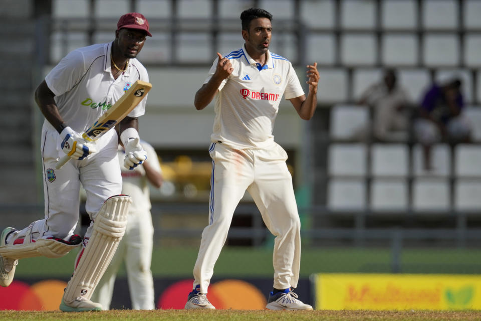 India's Ravichandran Ashwin reacts next to West Indies' Jason Holder while bowling on day three of their first cricket Test match at Windsor Park in Roseau, Dominica, Friday, July 14, 2023. (AP Photo/Ricardo Mazalan)
