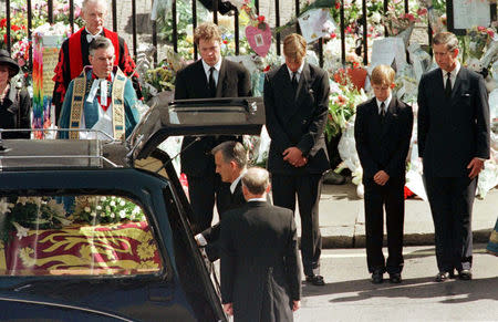 FILE PHOTO: Earl Spencer, Prince William, Prince Harry and Prince Charles watch as the coffin of Diana, Princess of Wales is placed into a hearse at Westminster Abbey following her funeral service, London, Britain September 6, 1997. REUTERS/Kieran Doherty/File Photo