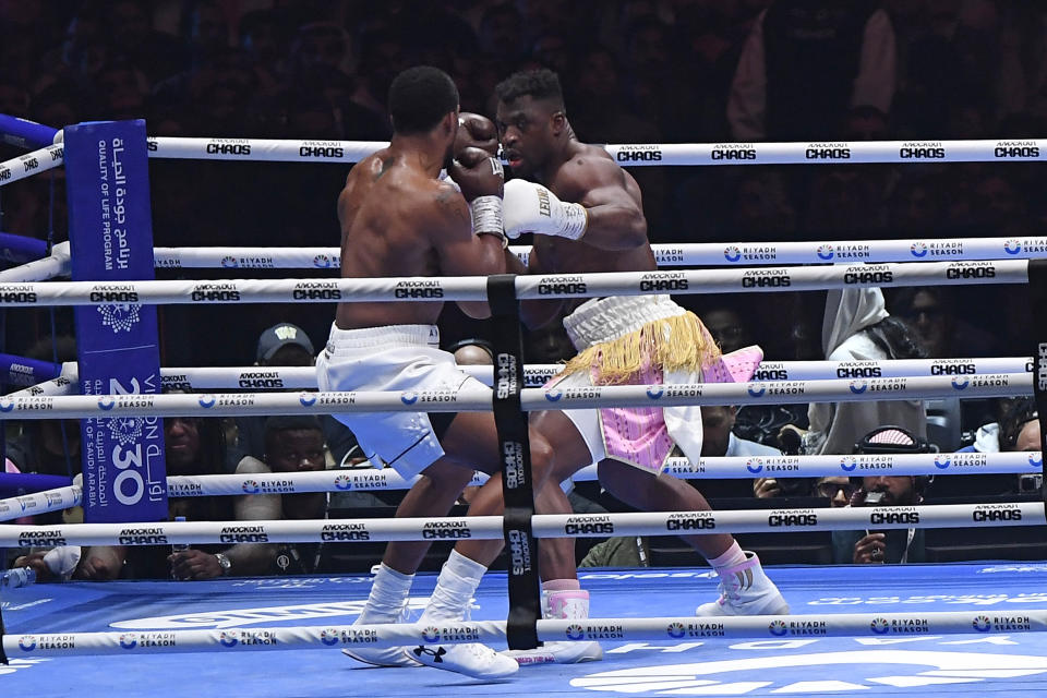 British former world champion Anthony Joshua, left, and MMA fighter Francis Ngannou fight during the heavyweight boxing showdown at Kingdom Arena in Riyadh, Saudi Arabia, Saturday, March 9, 2024. (AP Photo)