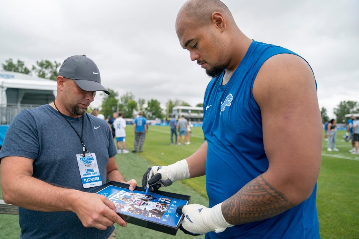 Michael Nahal, 44, of Jackson, says he feels like a little kid as he gets the autograph of newly drafted Lion Giovanni Manu after Manu works out at practice on Tuesday, July 30, 2024, at the Lions practice facility in Allen Park. Manu was the Lions fourth round draft pick and was announced during the NFL Draft in Detroit in April by Michigan Governor Gretchen Whitmer.