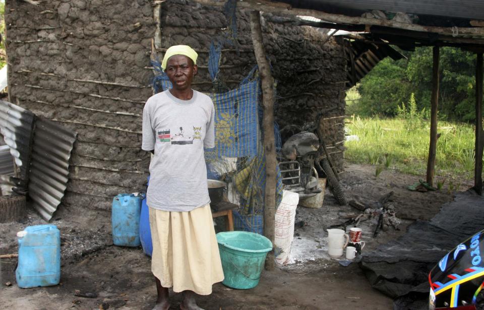 A woman stands outside a partly destroyed house after gunmen attacked Hindi village, near Lamu