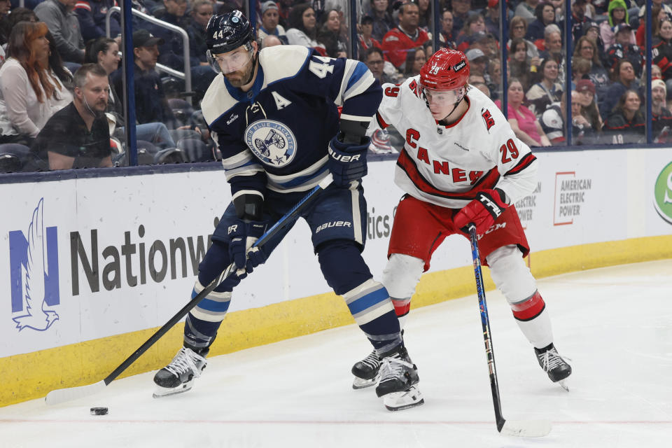 Columbus Blue Jackets' Erik Gudbranson, left, clears the puck as Carolina Hurricanes' Bradly Nadeau defends during the first period of an NHL hockey game Tuesday, April 16, 2024, in Columbus, Ohio. (AP Photo/Jay LaPrete)