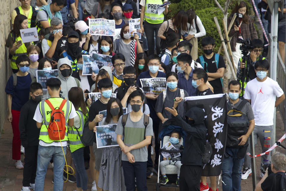 Padres e hijos participan en una marcha para protestar contra la exposición de gas lacrimógeno lanzado por la policía en Hong Kong, el sábado 23 de noviembre de 2019. (AP Foto/Ng Han Guan)