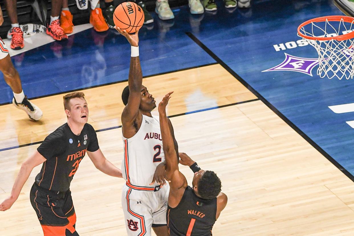 Auburn University forward Jaylin Williams (2) shoots near University of Miami forward Anthony Walker (1) during the first half of the NCAA Div. 1 Men's Basketball Tournament preliminary round game at Bon Secours Wellness Arena in Greenville, S.C. Sunday, March 20, 2022.