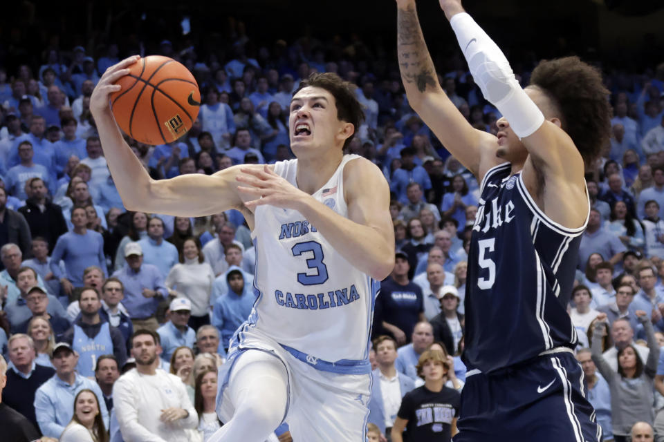 North Carolina guard Cormac Ryan (3) drives past Duke guard Tyrese Proctor (5) during the first half of an NCAA college basketball game Saturday, Feb. 3, 2024, in Chapel Hill, N.C. (AP Photo/Chris Seward)