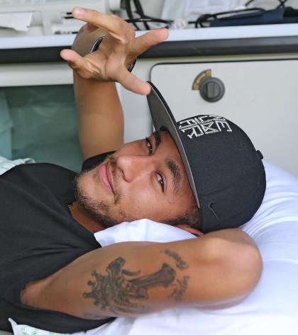 Brazil's Neymar gives a victory sign to the camera on Saturday, one day after suffering a cracked vertebrae. (AP)