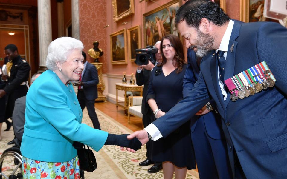 Queen Elizabeth II shakes hands with Willie Apiata - John Stillwell/AFP via Getty