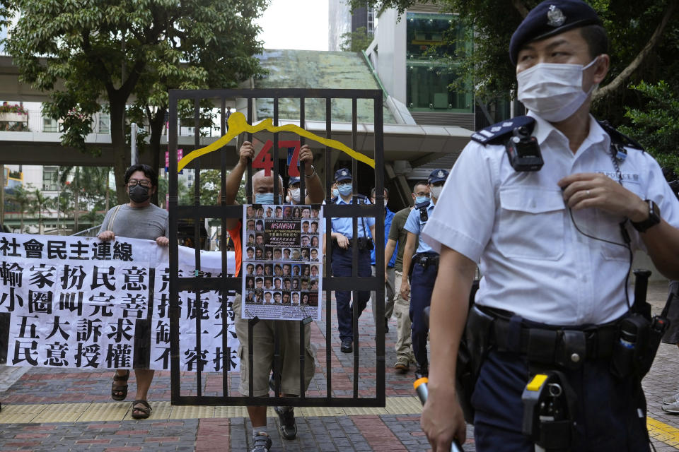 A police officer guard at a street during a protest against an election committee that will vote for the city's leader in Hong Kong Sunday, Sept. 19, 2021. Hong Kong's polls for an election committee that will vote for the city's leader kicked off Sunday amid heavy police presence, with chief executive Carrie Lam saying that it is "very meaningful" as it is the first election to take place following electoral reforms. (AP Photo/Vincent Yu)