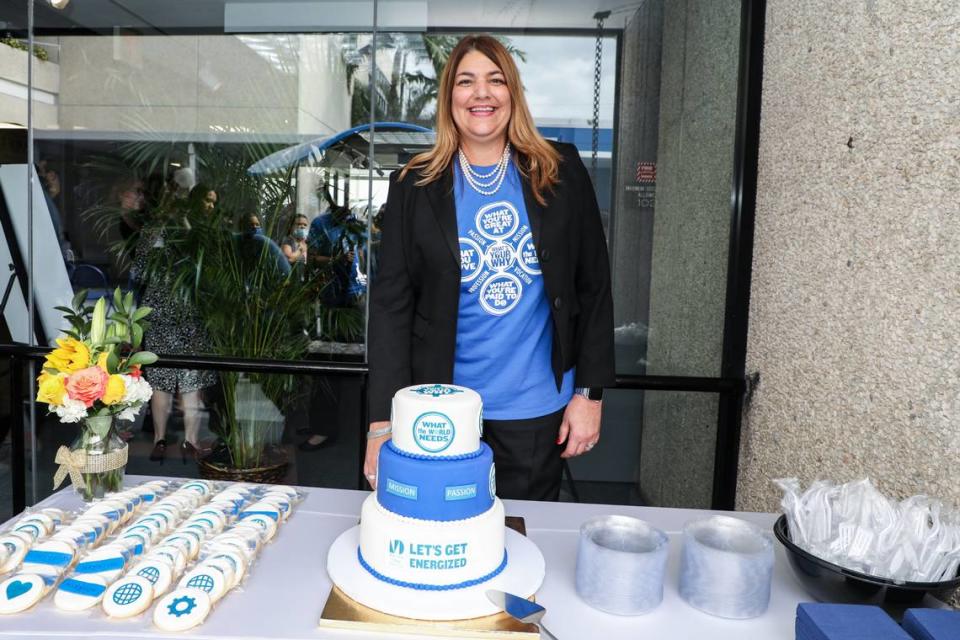 Miami Dade College President Madeline Pumariega poses with a three-tier cake that reads, in part, “Let’s get energized” during an investiture celebration for her on the college’s Medical Campus on Nov. 9, 2021.