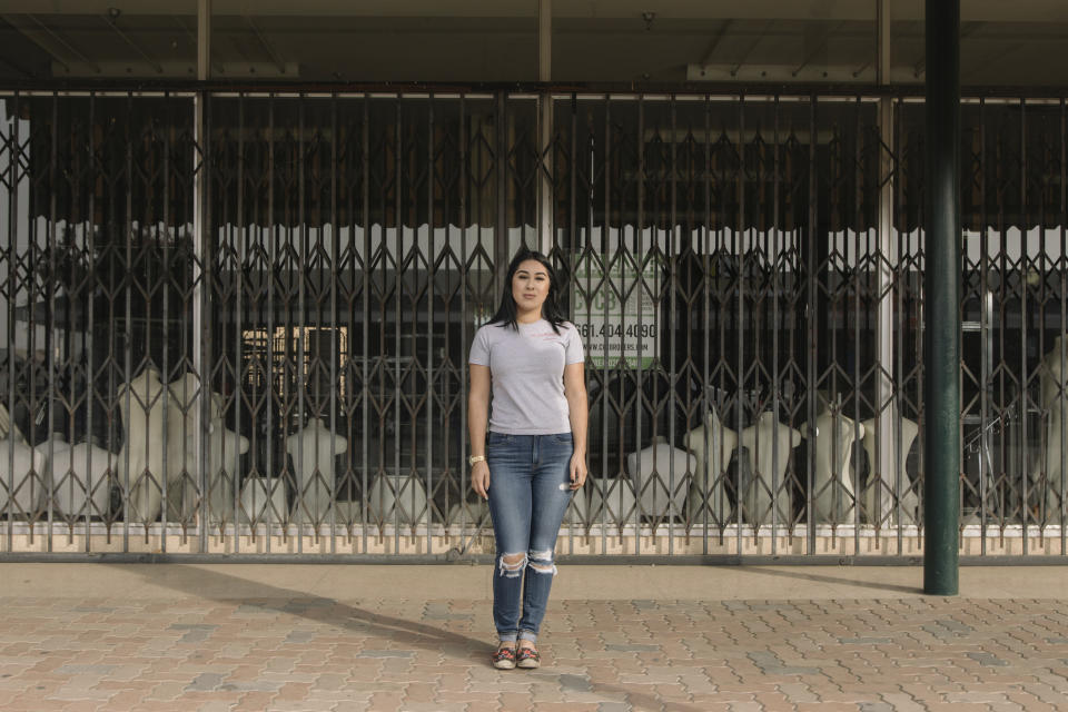 Alexandra Orozco stands for a portrait outside of the closed J.C. Penney where she was laid off from, in Delano, Calif., on Sunday, Dec. 6, 2020. “Not a lot of people worked there but the store really meant something to Delano,” she explains. “People are really sad. It’s the only place that sold nice, branded clothes, like Levi’s. And it’s been here for a very long time. My mom used to go shopping with her mom there but she can’t relive that memory because the store is gone.” (Madeline Tolle/The Fuller Project via AP)