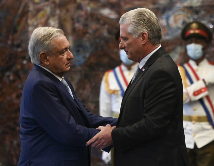 Cuban president Miguel Diaz Canel, right, shakes hands with his Mexican counterpart Andres Manuel Lopez Obrador at Revolution Palace in Havana, Cuba, Sunday, May 8, 2022. (Yamil Lage/Pool Photo via AP)