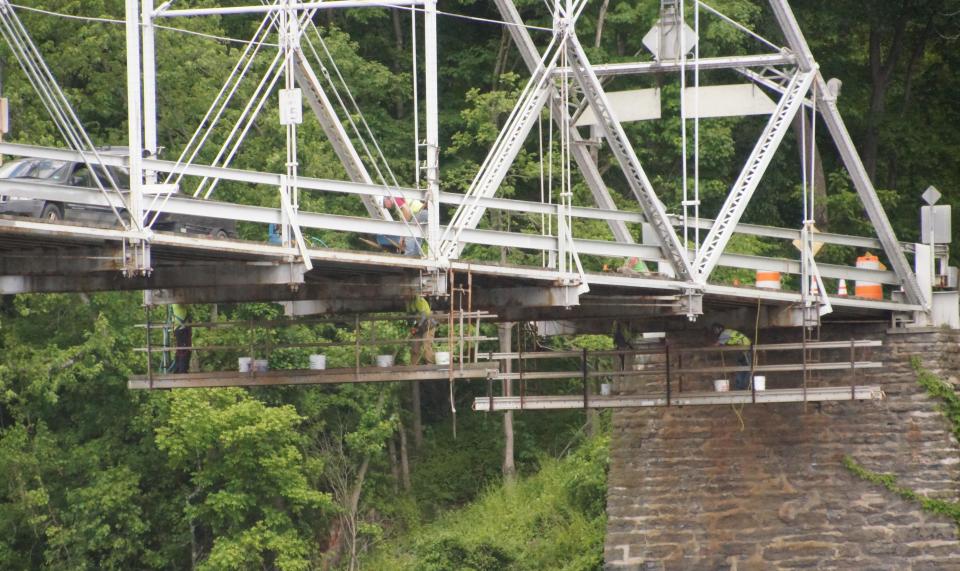 Workers can be seen Monday, June, 1, 2020, on scaffolding hanging from the underside of the Dingmans Ferry Bridge which is closed through June 12 for inspection and repairs. [Photo by Bruce A. Scruton/New Jersey Herald (NJH)]