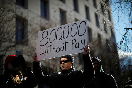 A demonstrator holds a sign, signifying hundreds of thousands of federal employees who won’t be receiving their paychecks as a result of the partial government shutdown, during a “Rally to End the Shutdown” in Washington, U.S., Jan. 10, 2019. REUTERS/Carlos Barria/Files