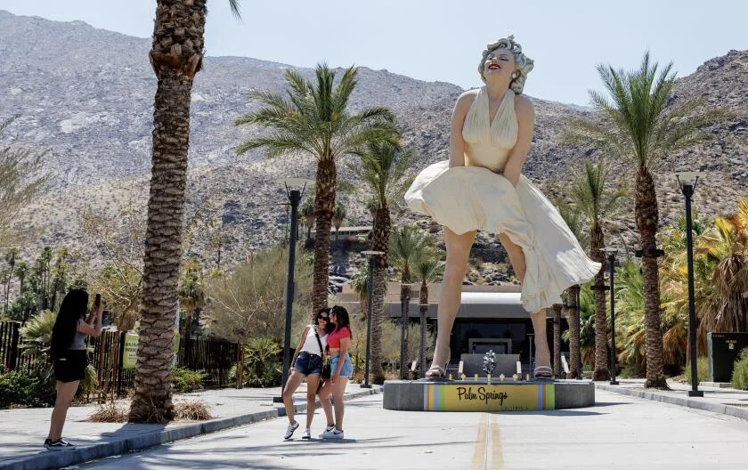 PALM SPRINGS, CA - JULY 8, 2024: Tourists take photos in front of the Marilyn Monroe statue as temperatures reach 118 degrees on July 8, 2024 in Palm Springs, California.(Gina Ferazzi / Los Angeles Times)