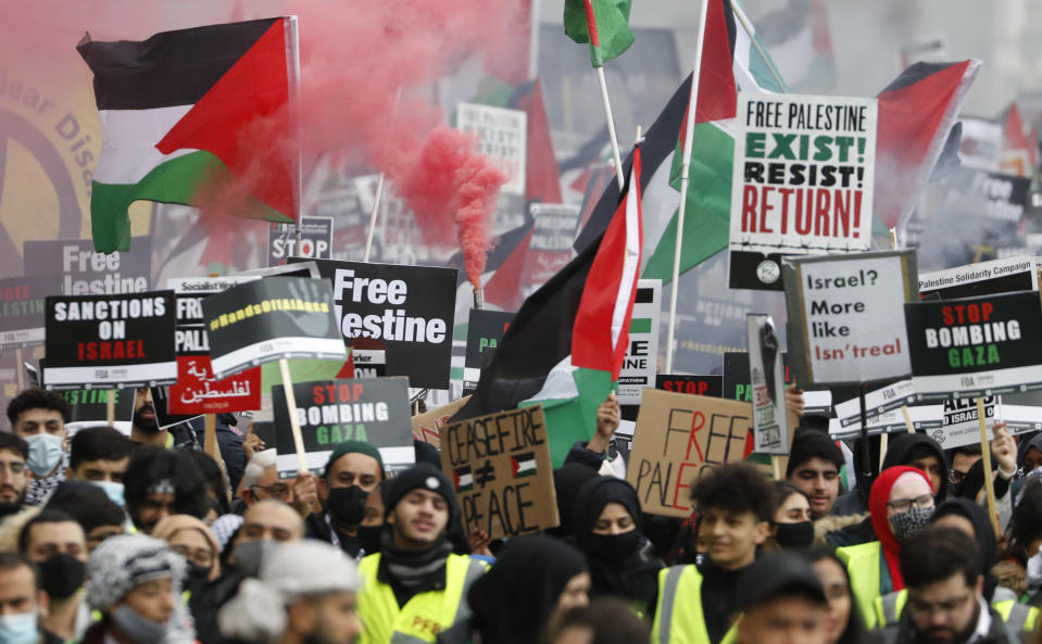 Protesters hold placards and banners in London, Saturday, May 22, 2021, as they take part in a rally supporting Palestinians. Egyptian mediators held talks Saturday to firm up an Israel-Hamas cease-fire as Palestinians in the Hamas-ruled Gaza Strip began to assess the damage from 11 days of intense Israeli bombardment. (AP Photo/Alastair Grant)