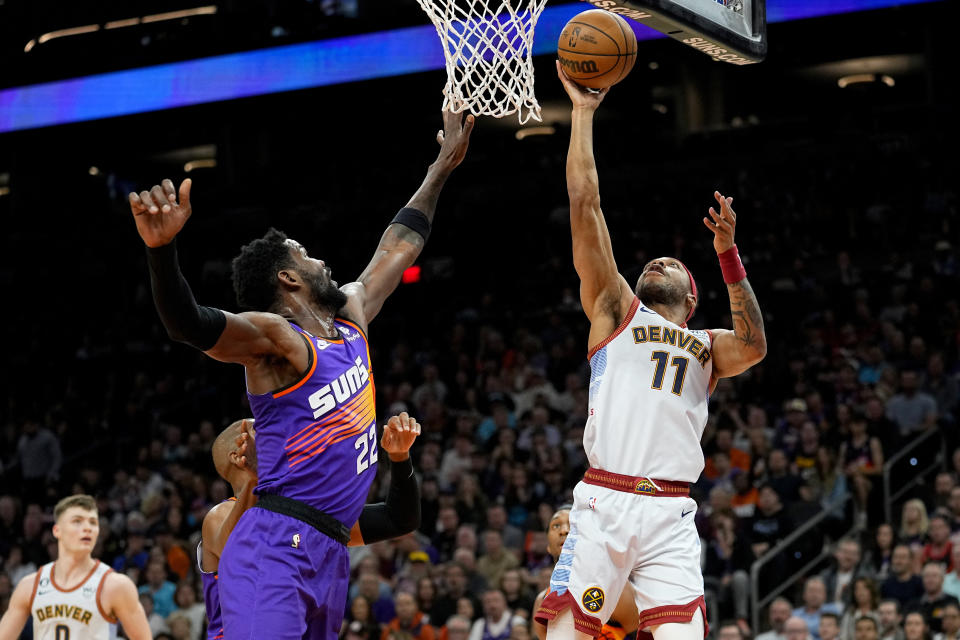 Denver Nuggets forward Bruce Brown (11) shoots as Phoenix Suns center Deandre Ayton (22) defends during the first half of an NBA basketball game, Friday, March 31, 2023, in Phoenix. (AP Photo/Matt York)