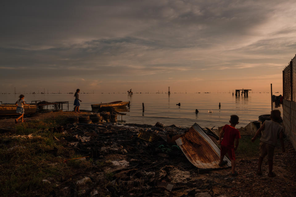 Niños juegan en los muelles de pesca abandonados y contaminados de petróleo crudo en Cabimas, Venezuela, en septiembre. (Adriana Loureiro Fernandez/The New York Times)