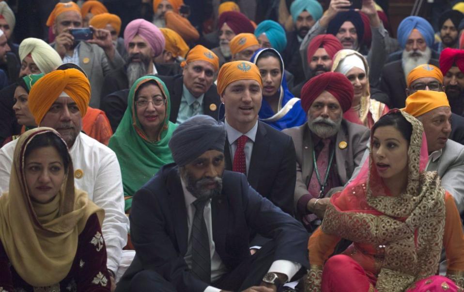 Prime Minister Justin Trudeau sits with members of the Sikh community and government caucus during a Vaisakhi Celebration on Parliament Hill in Ottawa, Monday, April 11, 2016. THE CANADIAN PRESS/Adrian Wyld