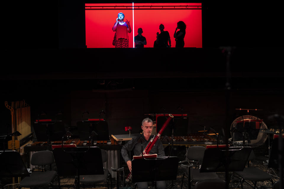 Un músico ensaya mientras los técnicos trabajan sobre el escenario antes de una representación de "Turandot", la ópera de Giacomo Puccini, en el Teatro Real de Madrid, el 14 de julio de 2023. Desde hace ocho años, el Teatro Real ofrece la retransmisión gratuita de las óperas que se representan en su escenario a pueblos y ciudades de toda España. El objetivo es incentivar el interés por la ópera y librarla de su etiqueta de elitista. (AP Foto/Bernat Armangué)