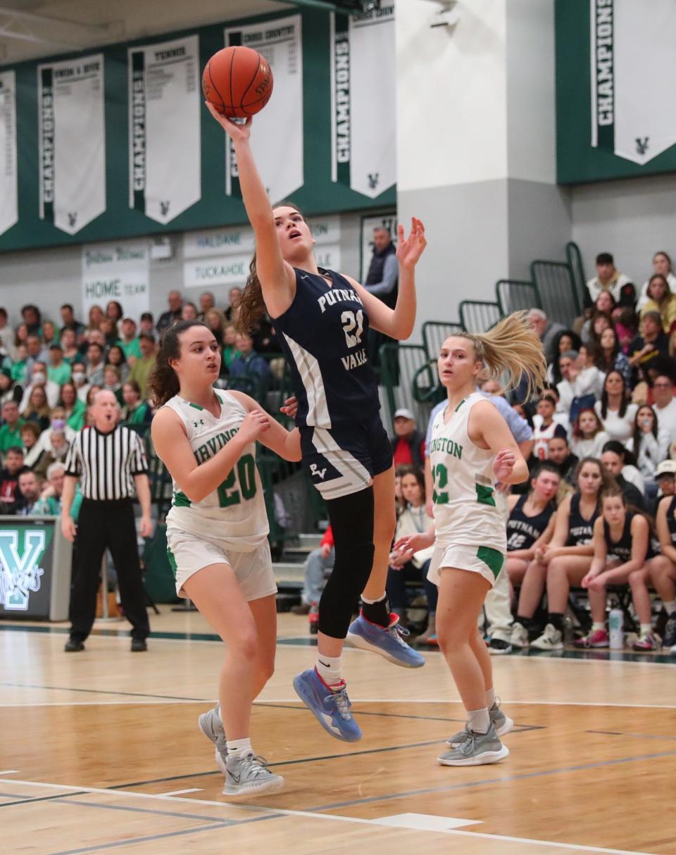 Putnam Valley's Eva DeChent (21) drives past Irvington's Alyson Raimondo (20) and Claire Friedlander (12) during the girls Section 1 Class B championship basketball game at Yorktown High School in Yorktown Heights on Saturday, March 5, 2022.