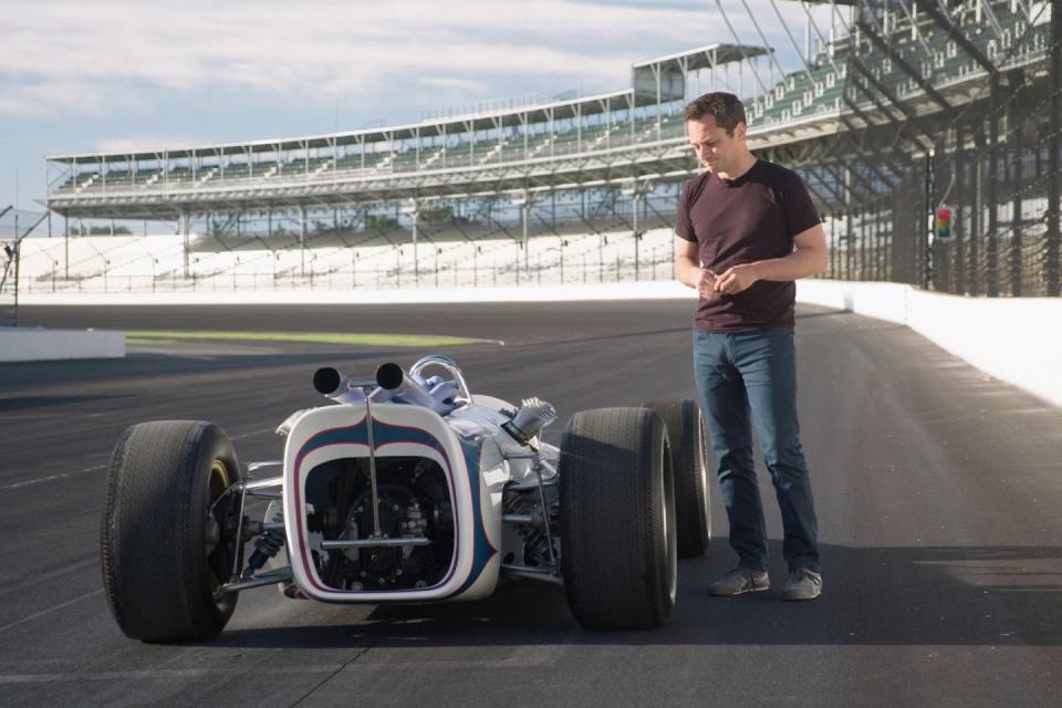 a man standing next to a race car