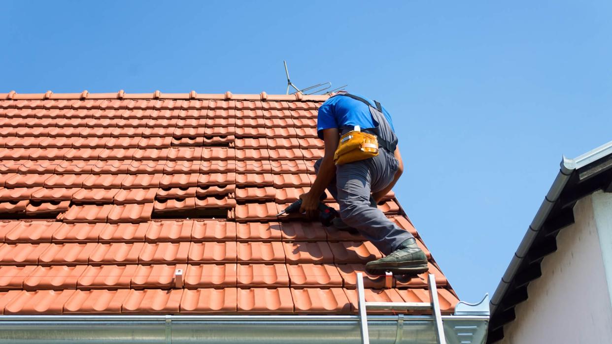man fixing damaged terra cotta roof