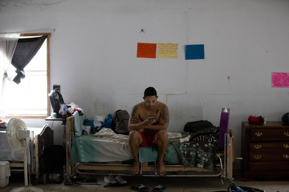 In this Oct. 12, 2019 photo, a Cuban migrant checks his cell phone at a migrant shelter in Reynosa, Mexico, Saturday, Oct. 12, 2019. In years past, migrants seeking asylum in the United States moved quickly through this violent territory on their way to the U.S., but now due to Trump administration policies, they remain here for weeks and sometimes months as they await their U.S. court dates, often in the hands of gangsters who hold Tamaulipas state in a vice-like grip. (AP Photo/Fernando Llano)