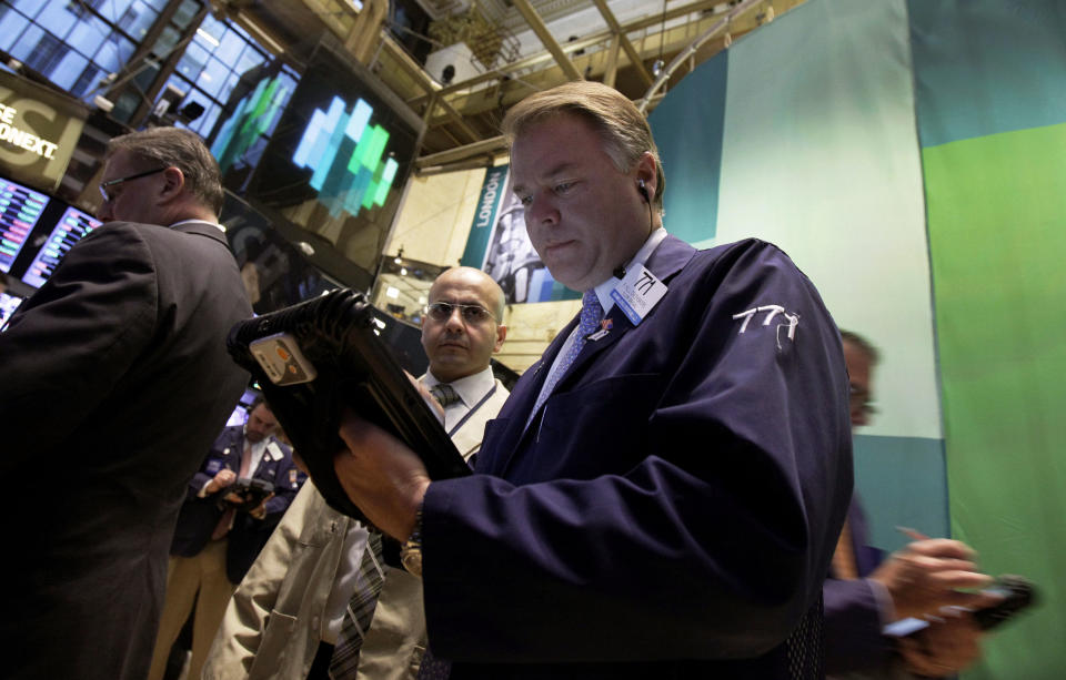 Trader F. Hill Creekmore, center, works on the floor of the New York Stock Exchange Monday, Oct. 22, 2012. A weak forecast from heavy equipment maker Caterpillar and other poor earnings results weighed on the U.S. stock market in early trading. (AP Photo/Richard Drew)