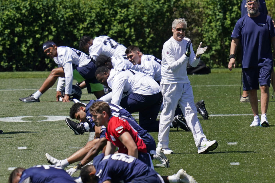 Seattle Seahawks head coach Pete Carroll claps his hands as he walks past players stretching during an NFL football rookie minicamp Friday, May 14, 2021, at the team's training facility in Renton, Wash. (AP Photo/Elaine Thompson)