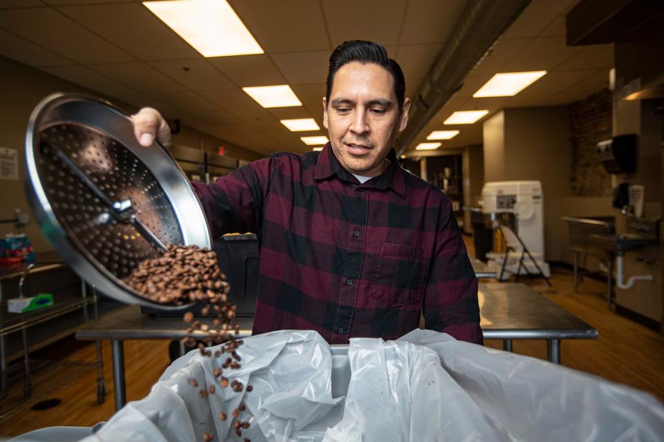 Jaime Perez pours roasted coffee beans into a container on Friday, Feb. 10, 2023, at Rockford City Market in Rockford.