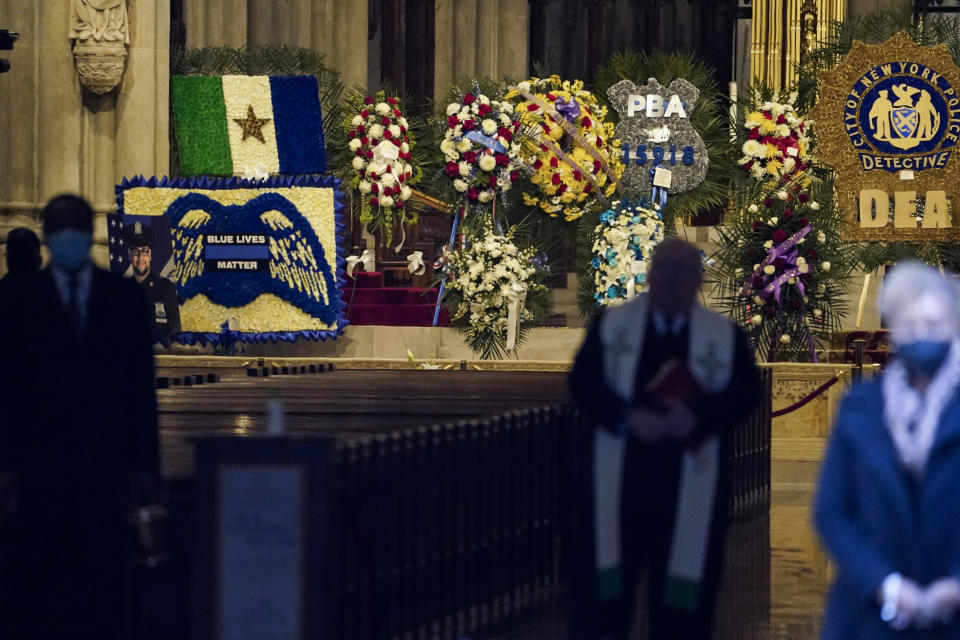 Flowers are displayed at the alter before the casket of New York City Police Officer Wilbert Mora is delivered to St. Patrick's Cathedral for his wake, Tuesday, Feb. 1, 2022, in New York. Mora and Officer Jason Rivera were fatally wounded when a gunman ambushed them in an apartment as they responded to a family dispute. (AP Photo/John Minchillo)