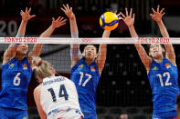 China's Gong Xiangyu, from left, China's Yan Ni and China's Li Yingying block a shot by United States' Michelle Bartsch-Hackley during the women's volleyball preliminary round pool B match between China and United States at the 2020 Summer Olympics, Tuesday, July 27, 2021, in Tokyo, Japan. (AP Photo/Frank Augstein)