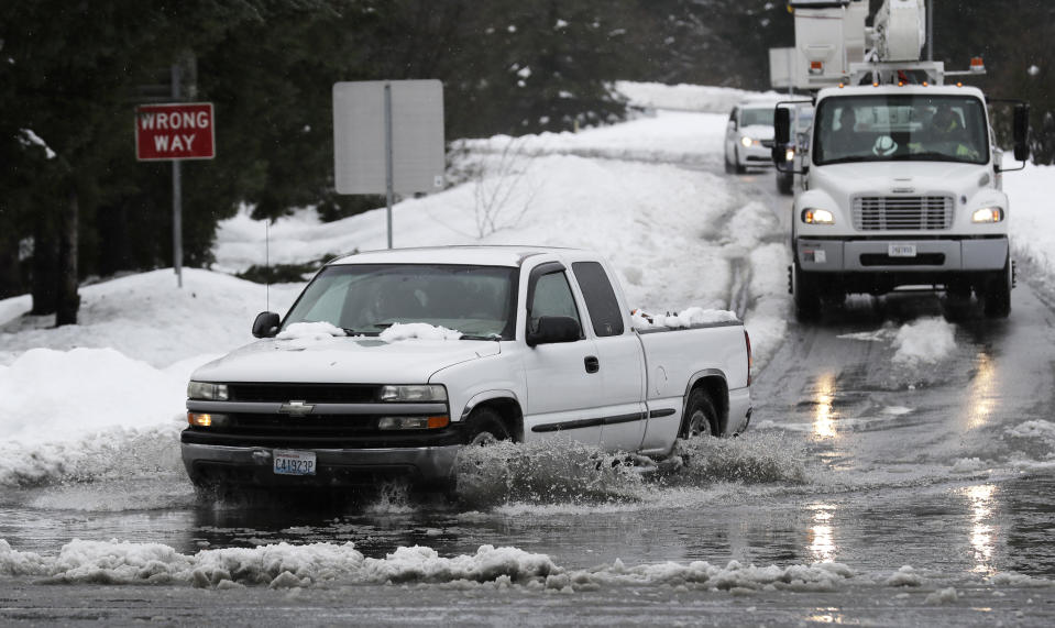 A truck drives through standing water on a highway offramp, Tuesday, Feb. 12, 2019, in Olympia, Wash. As heavy snow turned into rain Tuesday in the Pacific Northwest, crews worked to clear drains and roadways as concerns about flooding and drainage increased. February has been the snowiest month for the area in more than 50 years, and the National Weather Service issued a flood watch for northwest Oregon and parts of Washington through Wednesday morning. (AP Photo/Ted S. Warren)