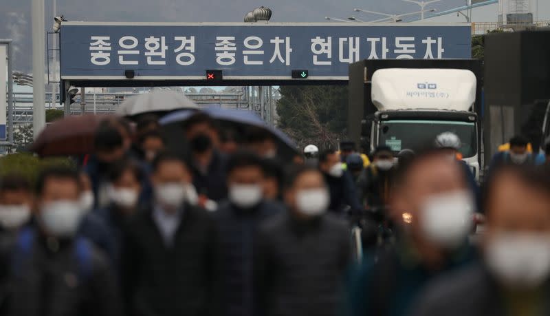 Employees wearing masks to prevent the coronavirus walk at a Hyundai Motors factory in Ulsan