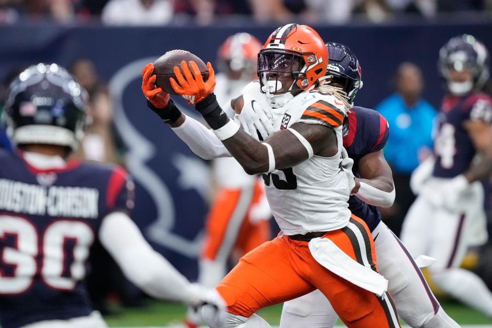 Cleveland Browns tight end David Njoku (85) catches a pass for a touchdown as Houston Texans linebacker Denzel Perryman (6) defends on Dec. 24, 2023, in Houston.